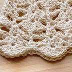 Close-up of a beige knitted cap on a wooden surface.