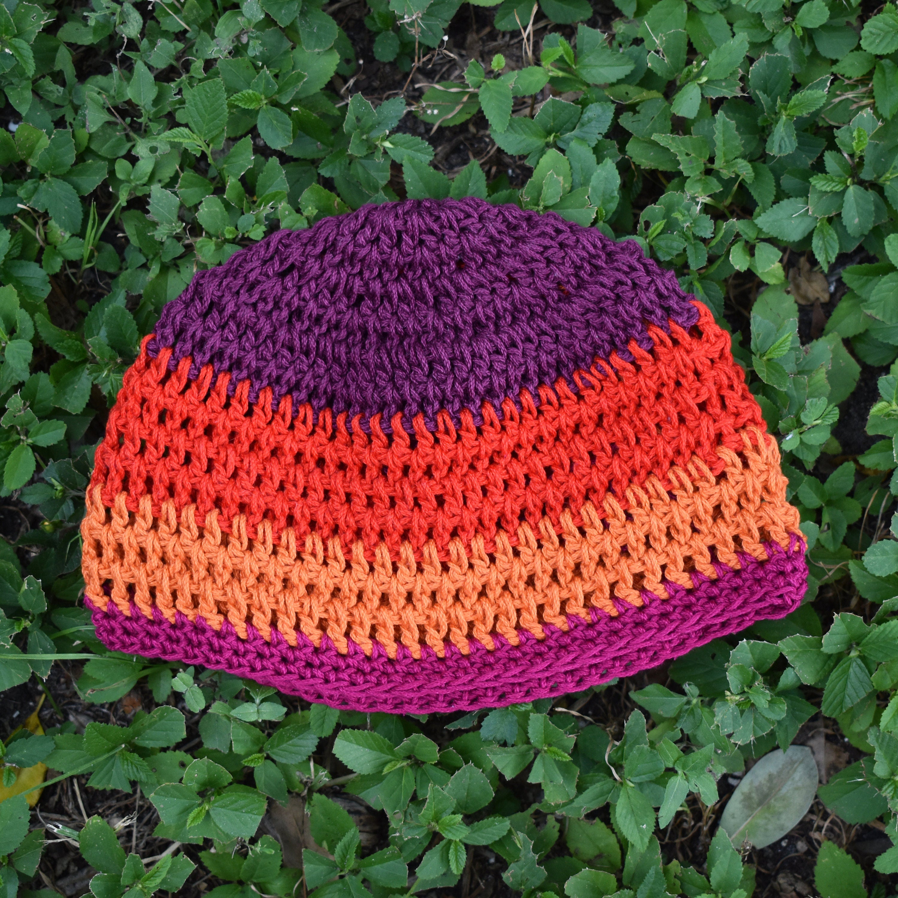 Colorful knitted beanie on a grassy background.