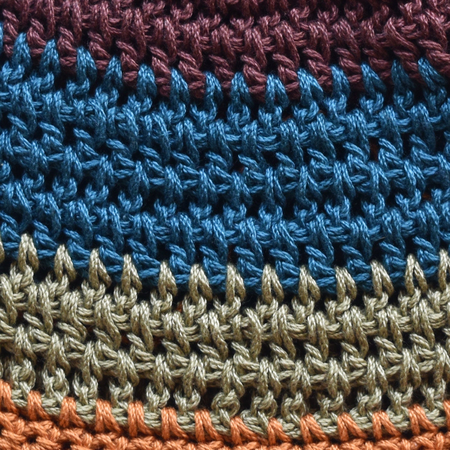 Close-up of a crocheted hat with a multicolored striped pattern.