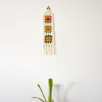Decorative wall hanging with a granny square design on a white background.