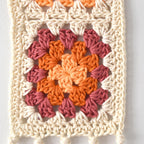 Crocheted square with a colorful granny square pattern on a white background.