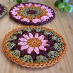 Crocheted coasters with a floral pattern on a wooden surface.