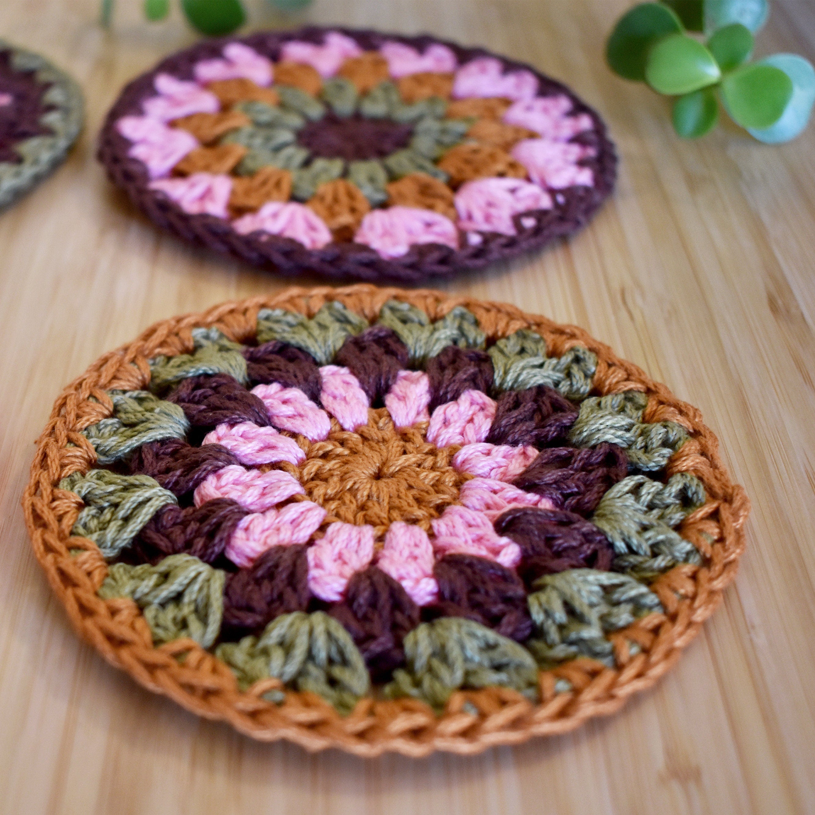 Crocheted coasters with a floral pattern on a wooden surface.