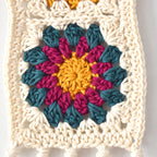 Colorful crocheted flower pattern on a white background.