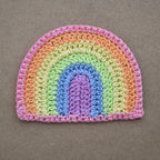 Crocheted pastel rainbow applique on a natural kraft background.