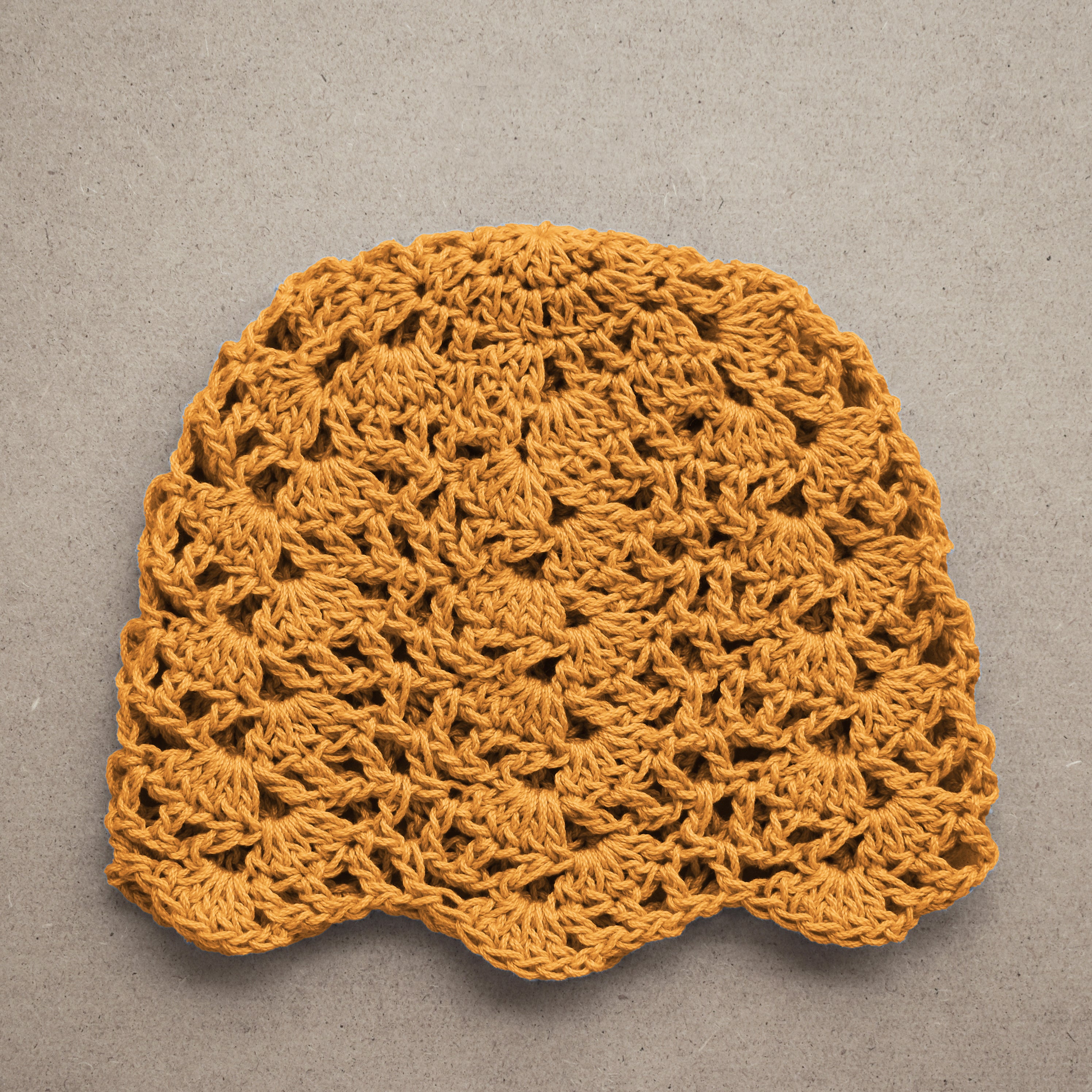 Crocheted yellow lace summer hat on a gray background.
