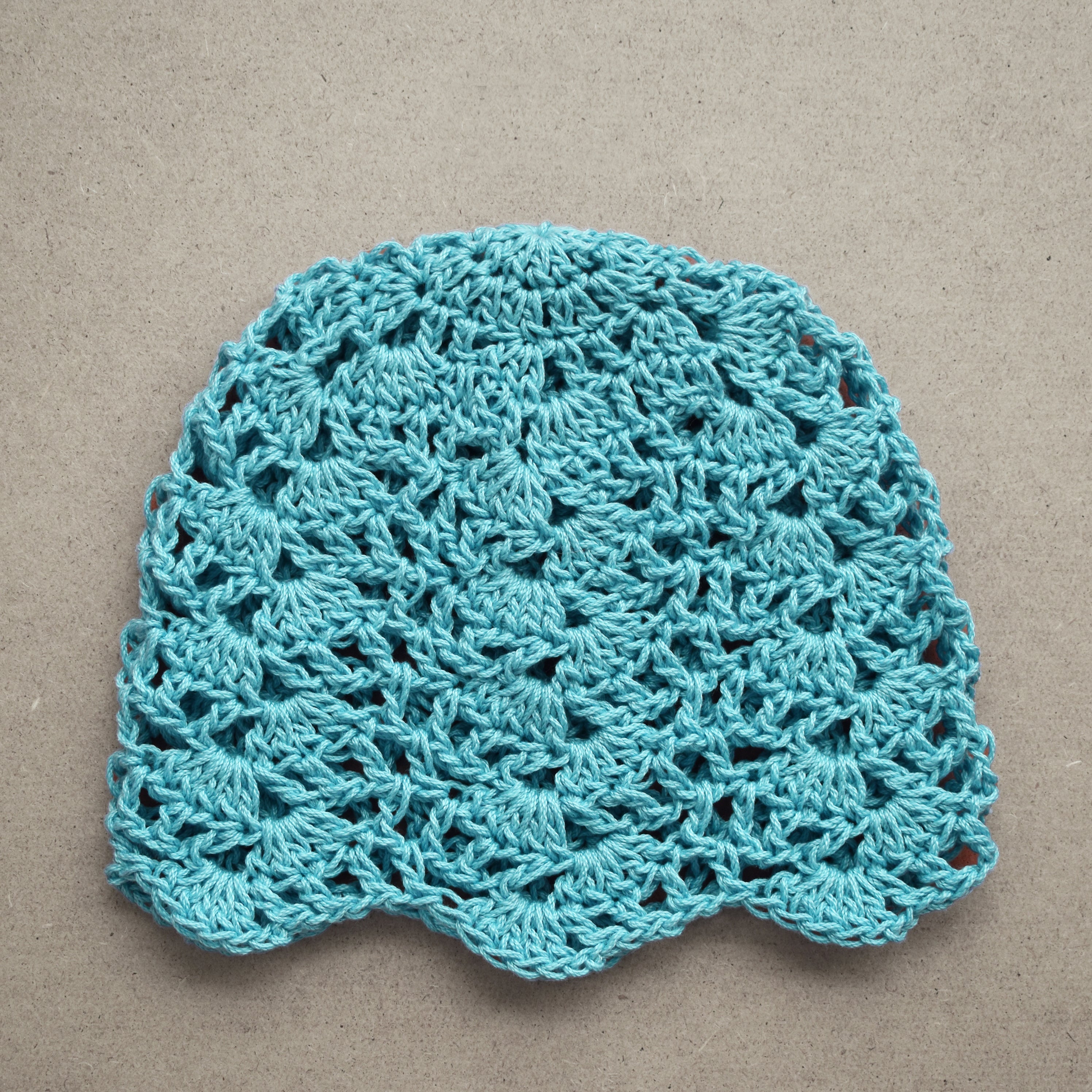 Light blue crocheted hat. on a beige background