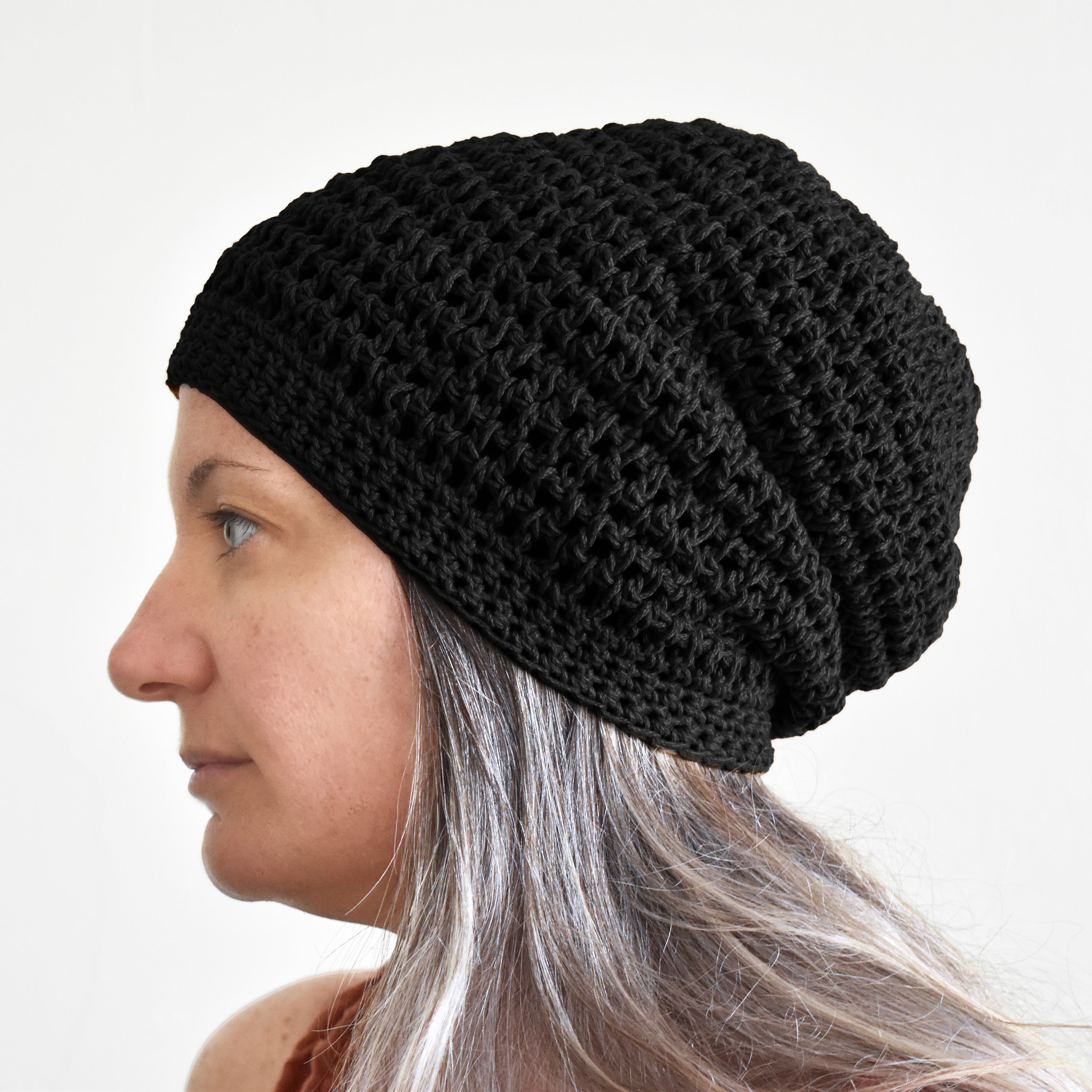 Person wearing a black knitted beanie against a white background.