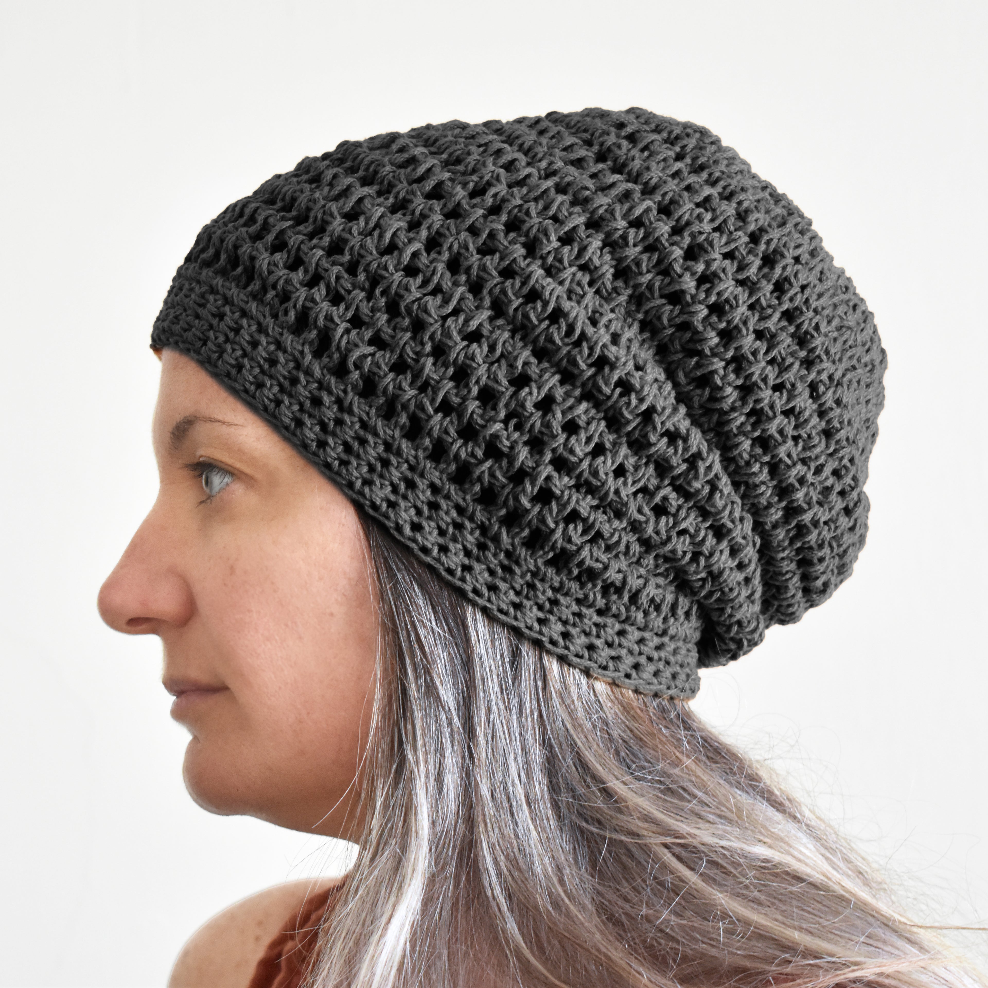 Woman wearing a gray knit beanie against a white background.