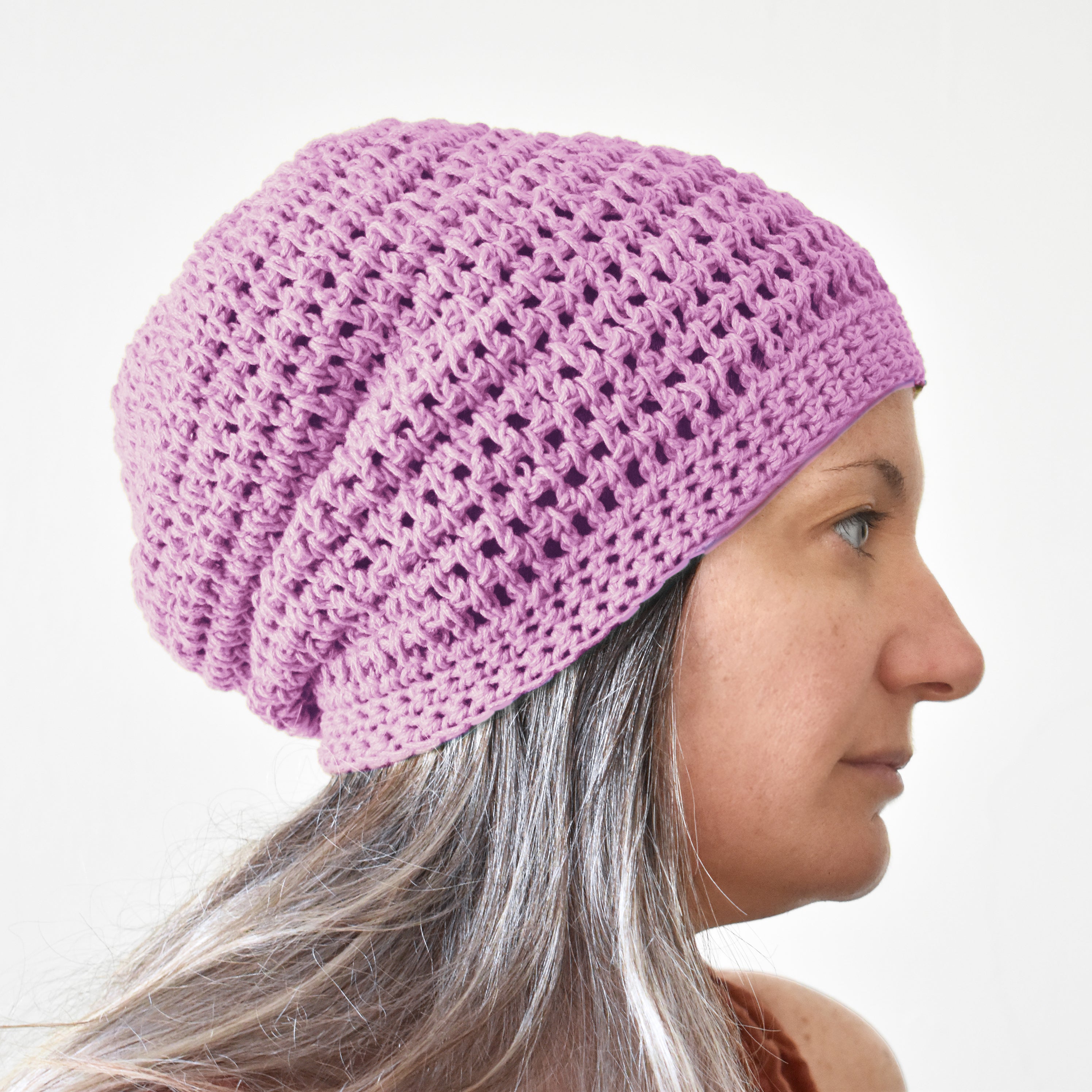 Person wearing a light purple knitted beanie on a white background.