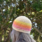 Colorful striped beanie worn by a person looking towards the trees in the background.