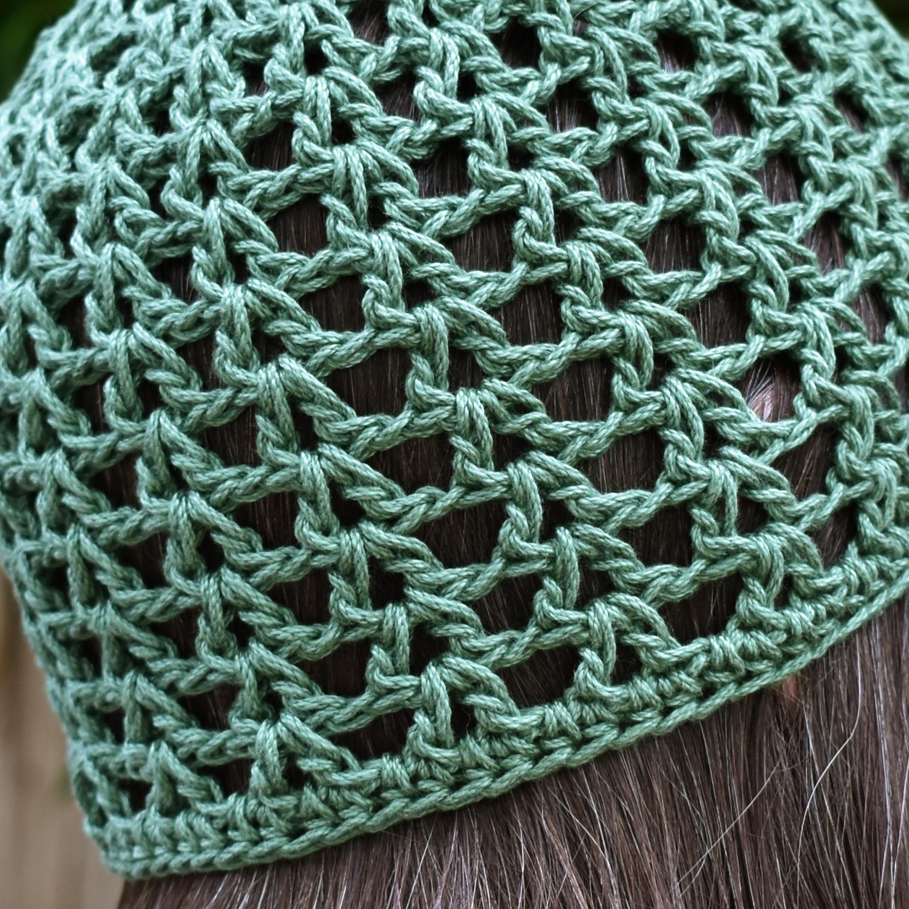 Close-up of a green knitted skull cap on a person's head.